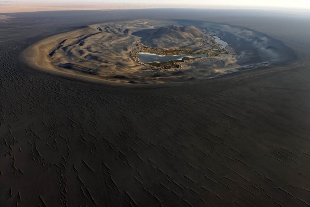 Wau al Namus an oasis in the middle of a dark volcanic field at the center of the Sahara Desert 