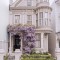 Wisteria blossoms surrounding the entrance of a Victorian townhouse in San Francisco