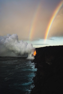 A beautiful double rainbow forms over a massive lava spout in Hawaii 