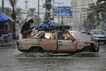 A car drives through a flooded road following heavy rain in Gaza City on December   Photo by Mohammed AbedAFP Photo x