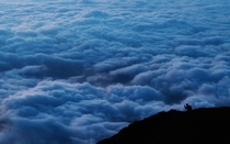 a climber stops to take pictures of clouds while climbing towards the summit of Mount Fuji to watch the sunrise in Japan