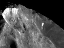 A closeup of Saturns small moon named Phoebe recorded by NASAs Cassini orbiter the white stuff in the craters is believed to be ice 