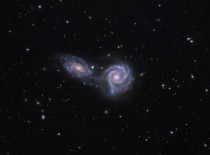 A hundred million light years away two spiral galaxies are locked in an embrace that may end with them merging a dance spread across a hundred thousand light years and tens of million years Arp  