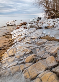 A layer of ice on the yellow sandstone by lake Vttern in Sweden 