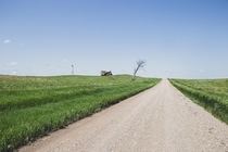 A lonely South Dakota road with an abandoned farmstead 