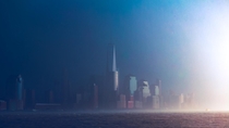 A narrow slit of light bursts through the clouds to light up New York City during a storm 