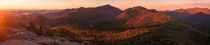 A panorama of the sunrise on Dix Mountain and the Adirondack Great Range from the summit of Noonmark Mountain NY USA 