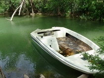 A peaceful abandoned fishing boat on a river in San Marcos TX 