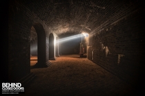 A single beam of light penetrates the darkness in an abandoned Victorian underground reservoir 