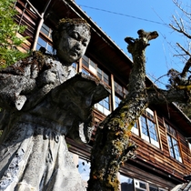 A statue of Niomiya Kinjiro standing in front of an abandoned junior school in the Nagano Prefecture Japan 