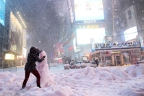 A woman decorates a snowman in Times Square as all cars but emergency vehicles are banned from driving on the road on January   Yana Paskova 