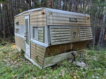 Abandoned camper trailer left in a forest on a BC island 