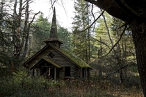 Abandoned church in the woods with a mossy rooftop and steeple Photo by Robert Wirth 