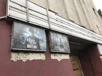Abandoned cinema with movie posters still outside - Derbyshire England 