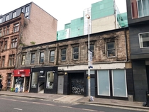Abandoned house in Glasgow with stores in ground floor still open 
