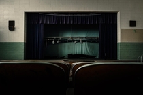abandoned school auditorium with blue curtains
