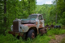 Abandoned truck on the side of a winding mountain road NCSC border 