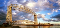 Aerial Lift Bridge in Duluth MN on the western tip of Lake Superior Center span is ftm rises kyr to full height of ftm in  min Connects Park Point neighborhood to Duluth sand bar island When crossing is prevented by nautical traffic locals call it Getting