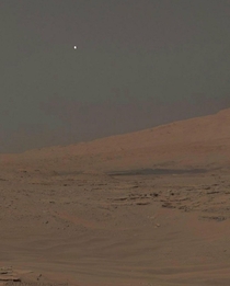 Afternoon on Mars Moon Phobos peeking over the northern limb of Mount Sharp