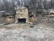 An abandoned foundation and fireplace on the side of a hill It incorporates the natural rock formations in the hill South Kansas City