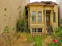 An abandoned home in San Francisco sandwiched between two modern apartment buildings on a residential street like the movie UP Photo by Wolfgang Schubert 