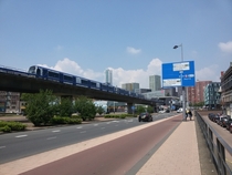 An elevated metro line three road lanes a cycle path and a sidewalk All next to each other in the city of Rotterdam Netherlands 
