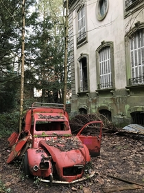 An old car next to an abandoned mansion France