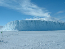 Antarcticas Barne Glacier where it meets the frozen ocean with Mt Erebus volcano smoking in the background 
