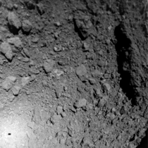 Asteroid Ryugu as seen from Hayabusas MASCOT lander Note MASCOTs shadow to the lower left and the huge boulder to the right which is tens of meters long