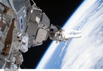 Astronaut Nicholas Patrick hangs from the cupola during the STS- missions third and final spacewalk 