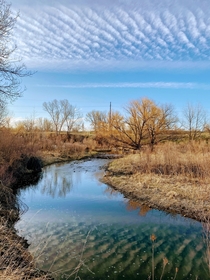 Clouds reflecting off a stream in Loveland Colorado 