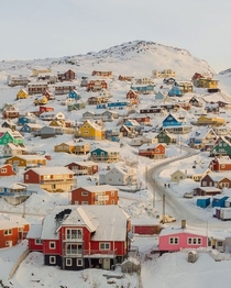 Colorful houses dotted across the snowy landsacpe in the town of Qaqortoq Kujalleq southern Greenland