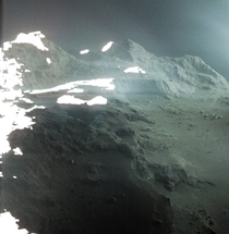 Colorized and slightly processed image of Comet Ps surface taken by Rosetta on September   Within a year part of the cliff on the lower left had collapsed due to the comets activity