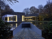 Cool house by DDM Architectuur with a driveway that goes under the pond in Antwerp Belgium 