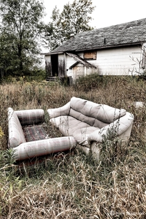 Couches left out to rot behind an abandoned home in Belleville Ontario