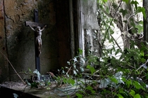 Crucifix in window of abandoned home Ireland 