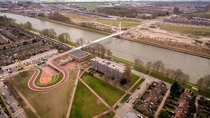 Cycling and walking bridge in Utrecht that uses a school roof as an approach ramp 