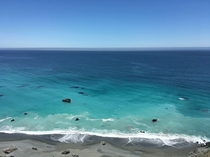 Dark sands meet rock-laden turquoise waters on a bright summer day along the central coast of California 
