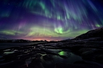 Display of the aurora borealis or northern lights taken over ponds near Hillesy in Norway
