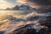 Dramatic morning light on crashing waves Lofoten Norway 