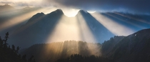 Early morning rays pierce through the fog and smoke in the North Cascades Washington 