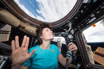 ESA Astronaut Samantha Cristoforetti in space wearing a Star Trek shirt doing a Vulcan salute 