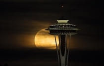 Full moon rising behind space needle in Seattle 