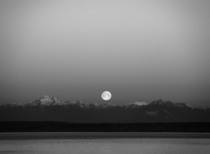 Full moon setting over the Olympic Mountains blackwhite seen from Seattle 