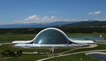 Georgian Parliament building in Kutaisi  In front of the lush Caucasus mountains