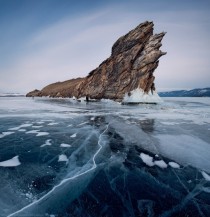 Giant rock surrounded by cracked ice of Lake Baikal Siberia 