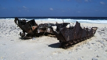 Hull of an Amtrac an armoured amphibious transport probably an LVT- rusting on a tropical beach 