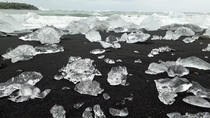 Ice crystals lying in black lava sand Diamond beach Iceland 