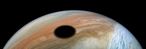 Jupiters volcanically active moon Io casts its shadow on the planet - taken from NASAs Juno spacecraft