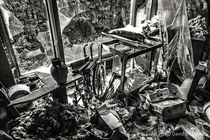 Living room with smashed window in an abandoned home in Ontario